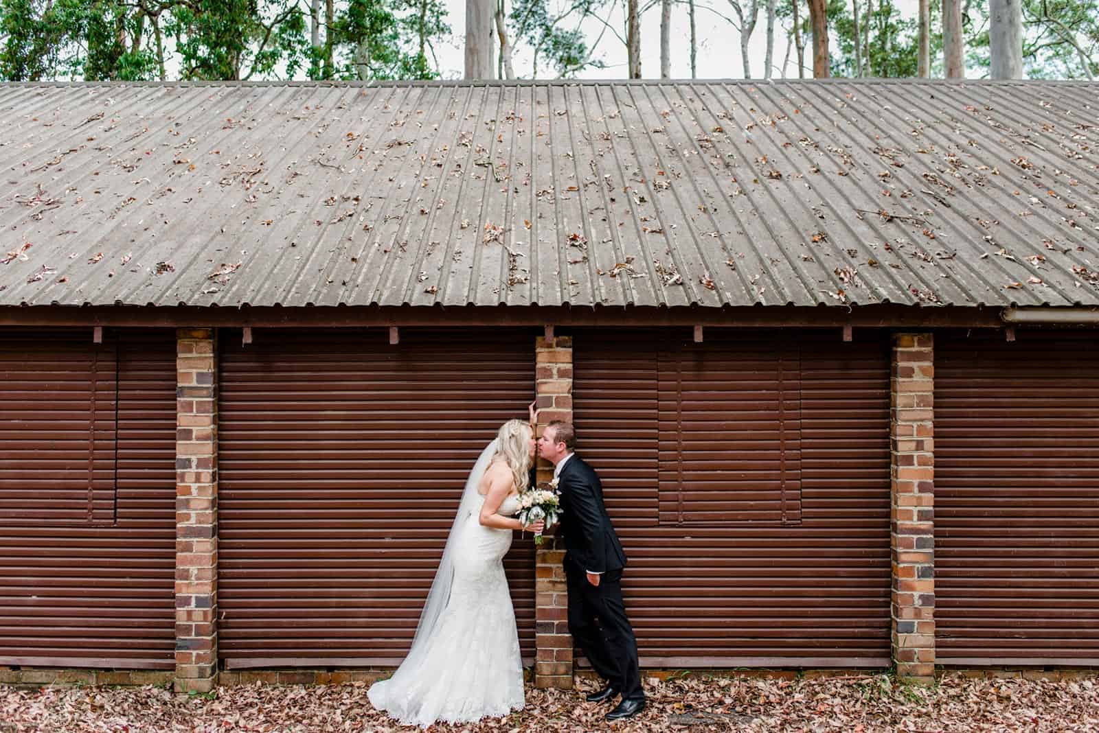 Bride and groom kiss in front of the garage door