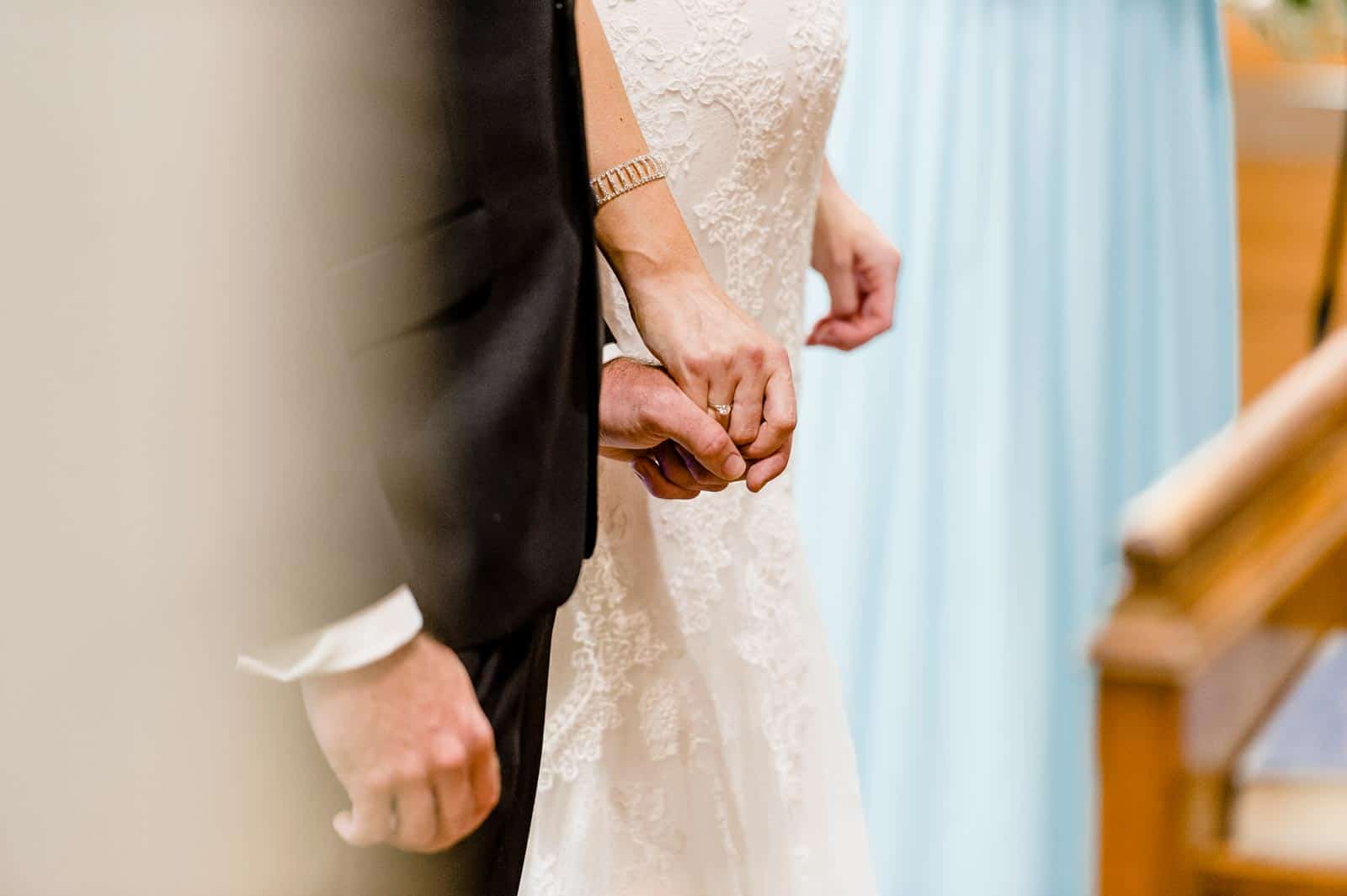 Holding hands during their wedding ceremony