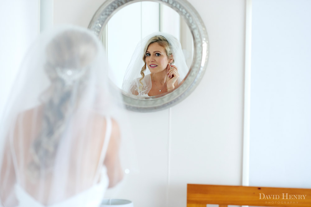Bride checking her earrings in mirror