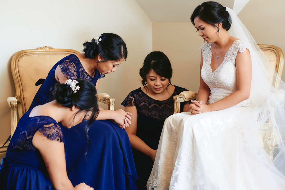 Prayer with bridesmaids before wedding ceremony at Oatlands House
