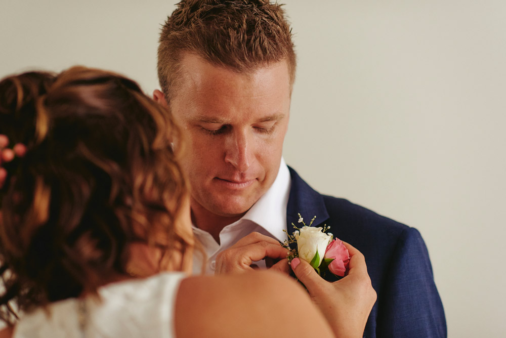 Attaching his buttonhole flowers