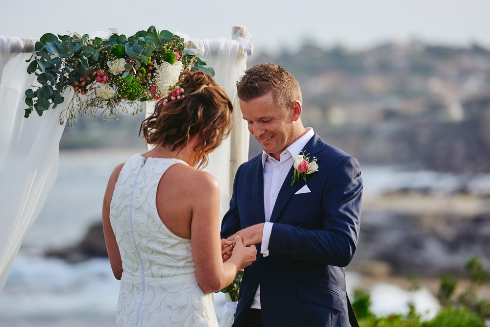 Putting on the wedding rings at Coogee