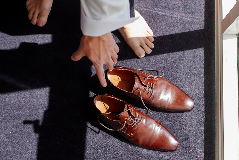 groom reaching for his shoes