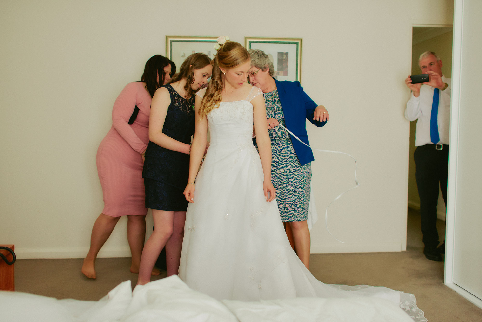 Helping the bride into her wedding dress