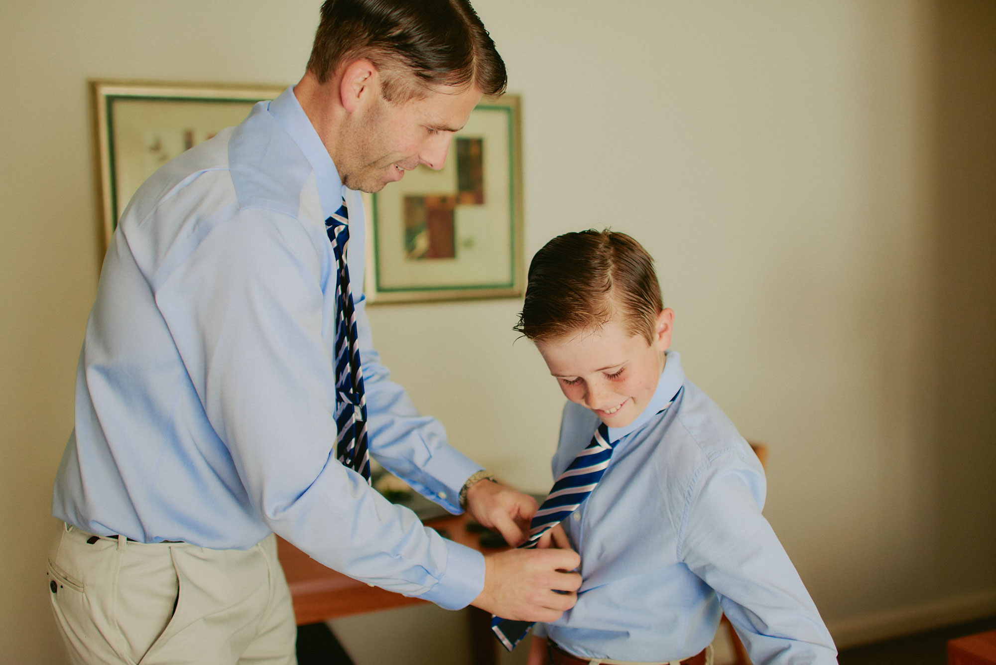 Bridegroom helping son put on his tie
