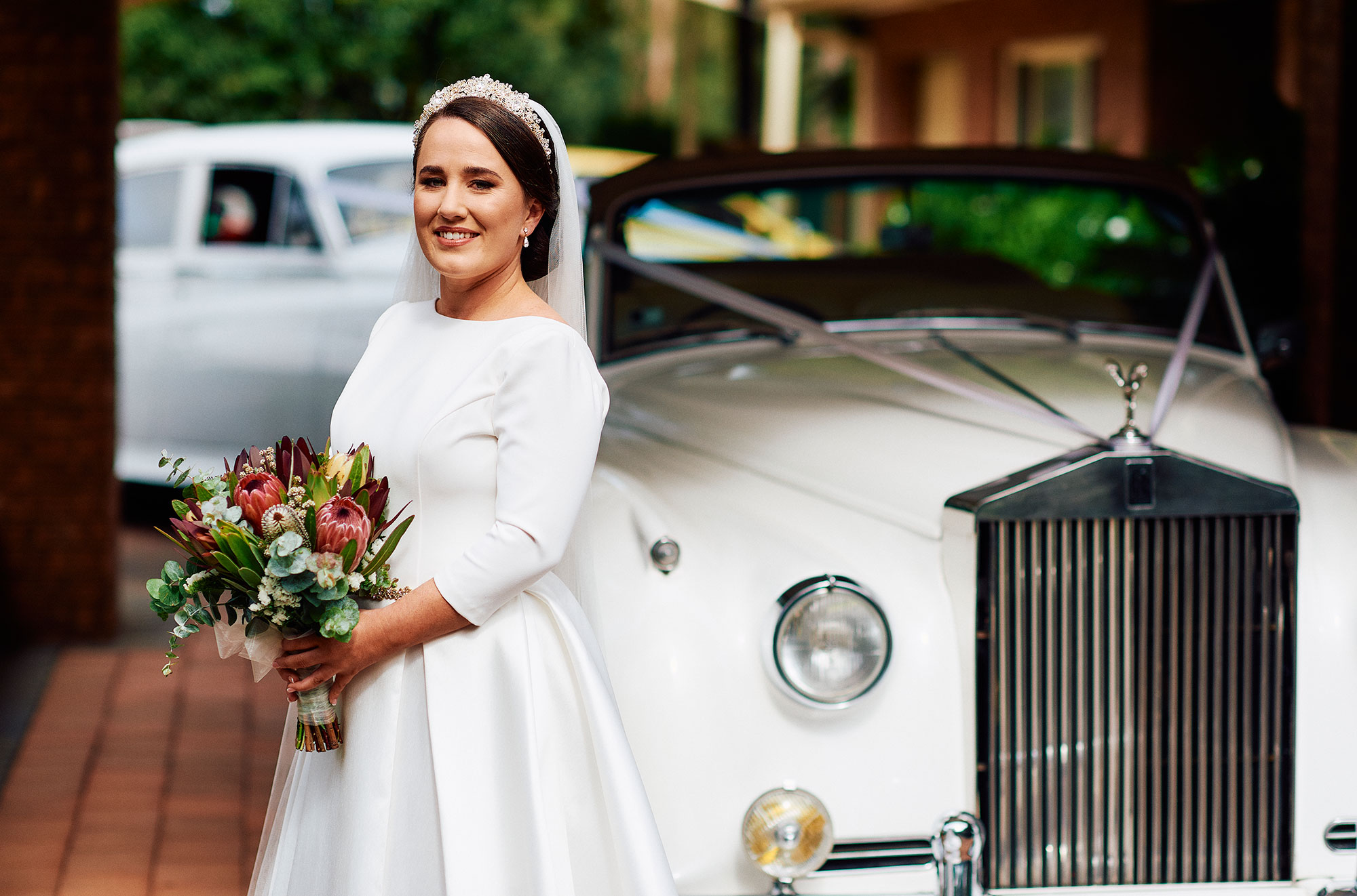 Bride with vintage wedding car