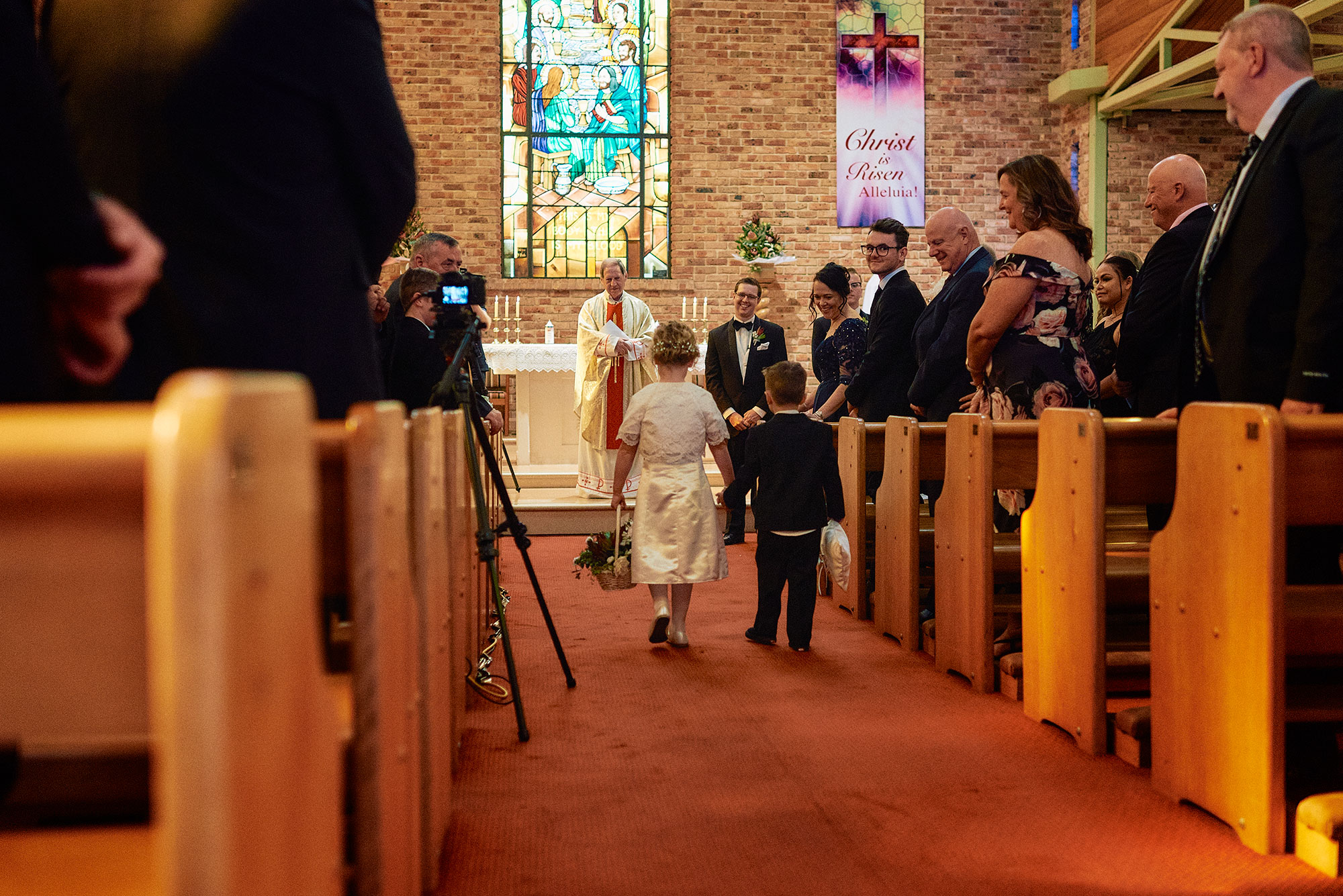 Flower girl and page boy walking down aisle