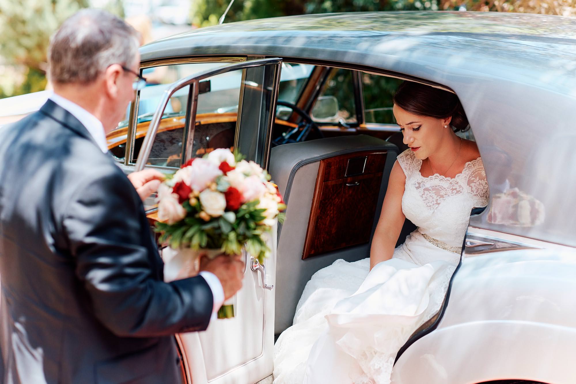 Bride alighting from the wedding car for her wedding ceremony