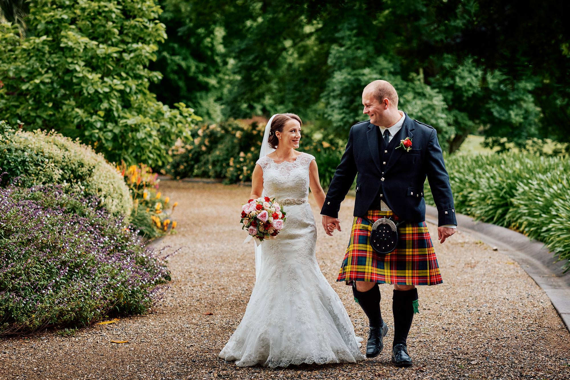 Bride and Groom happily walk through gardens of Peppers Craigieburn