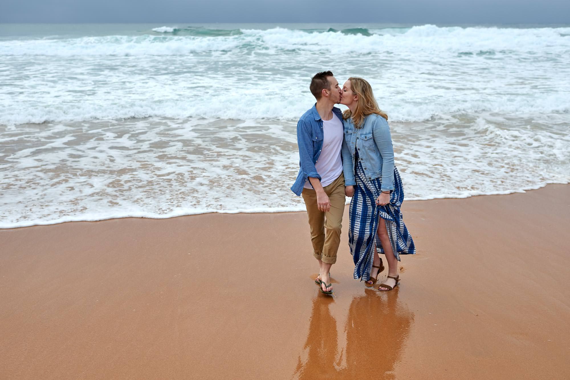 a kiss on the beach during their engagement session