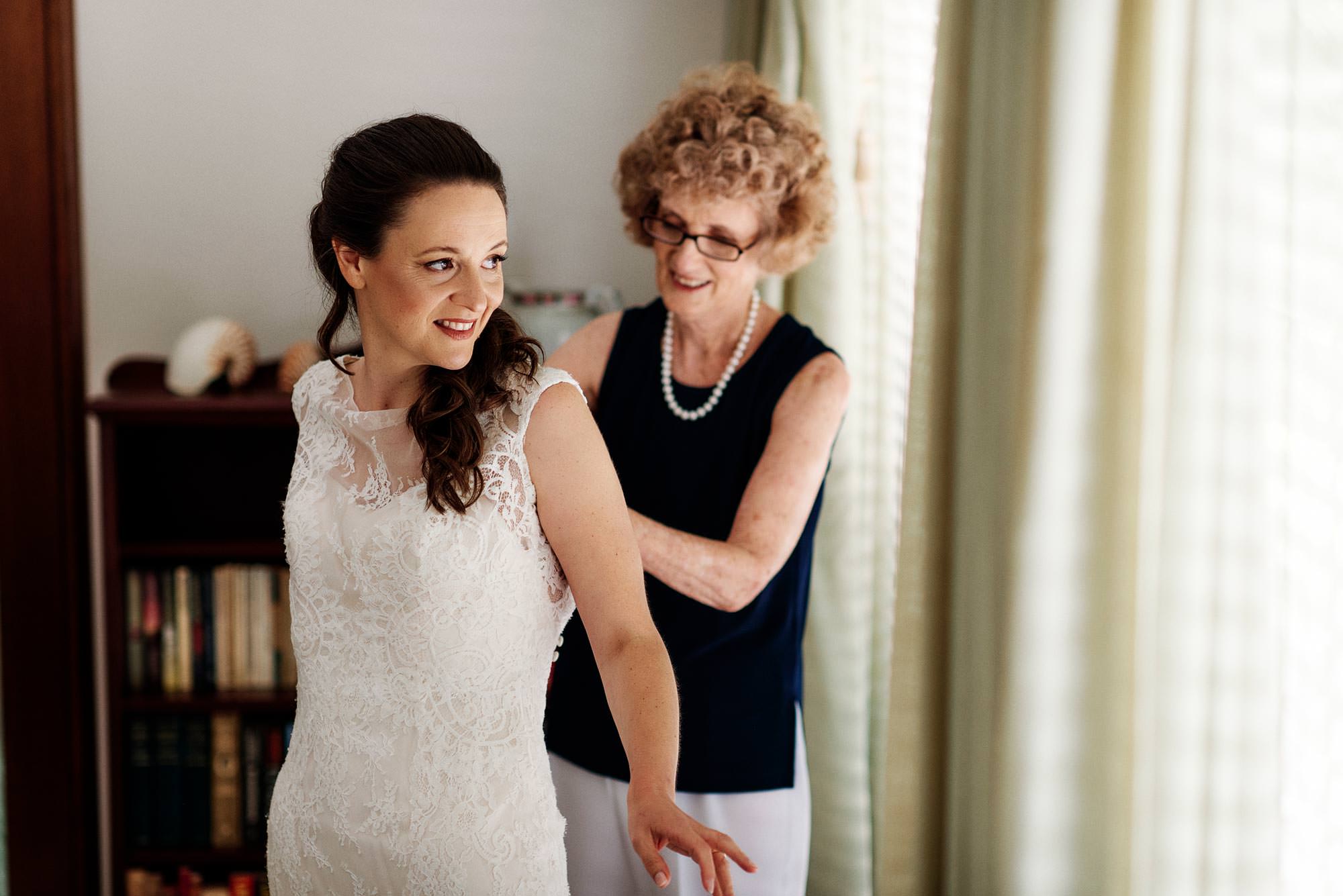 Mum helping daughter into wedding dress