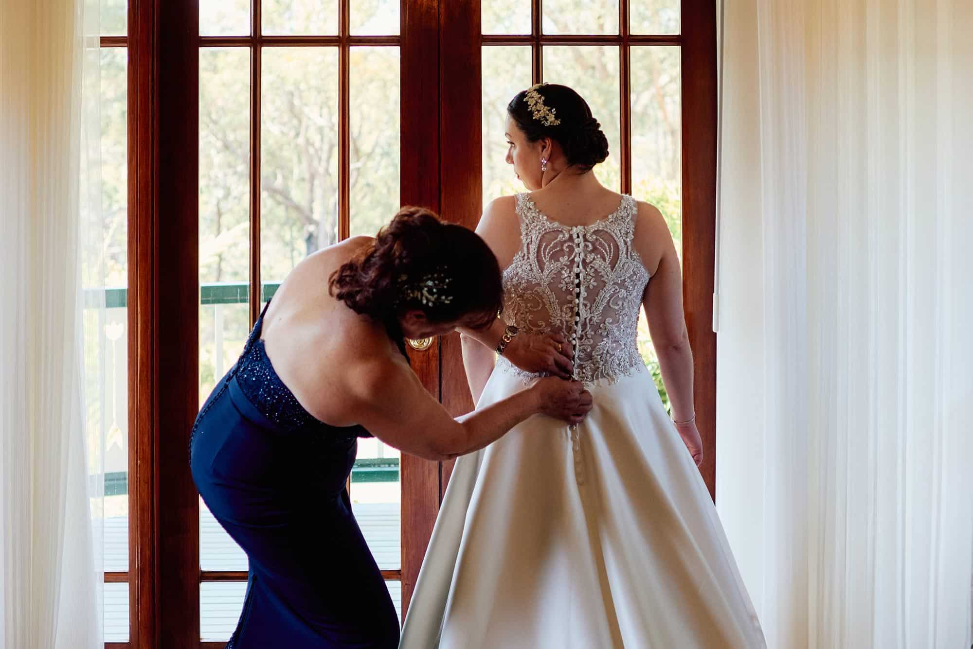 Buttoning up the bride's dress