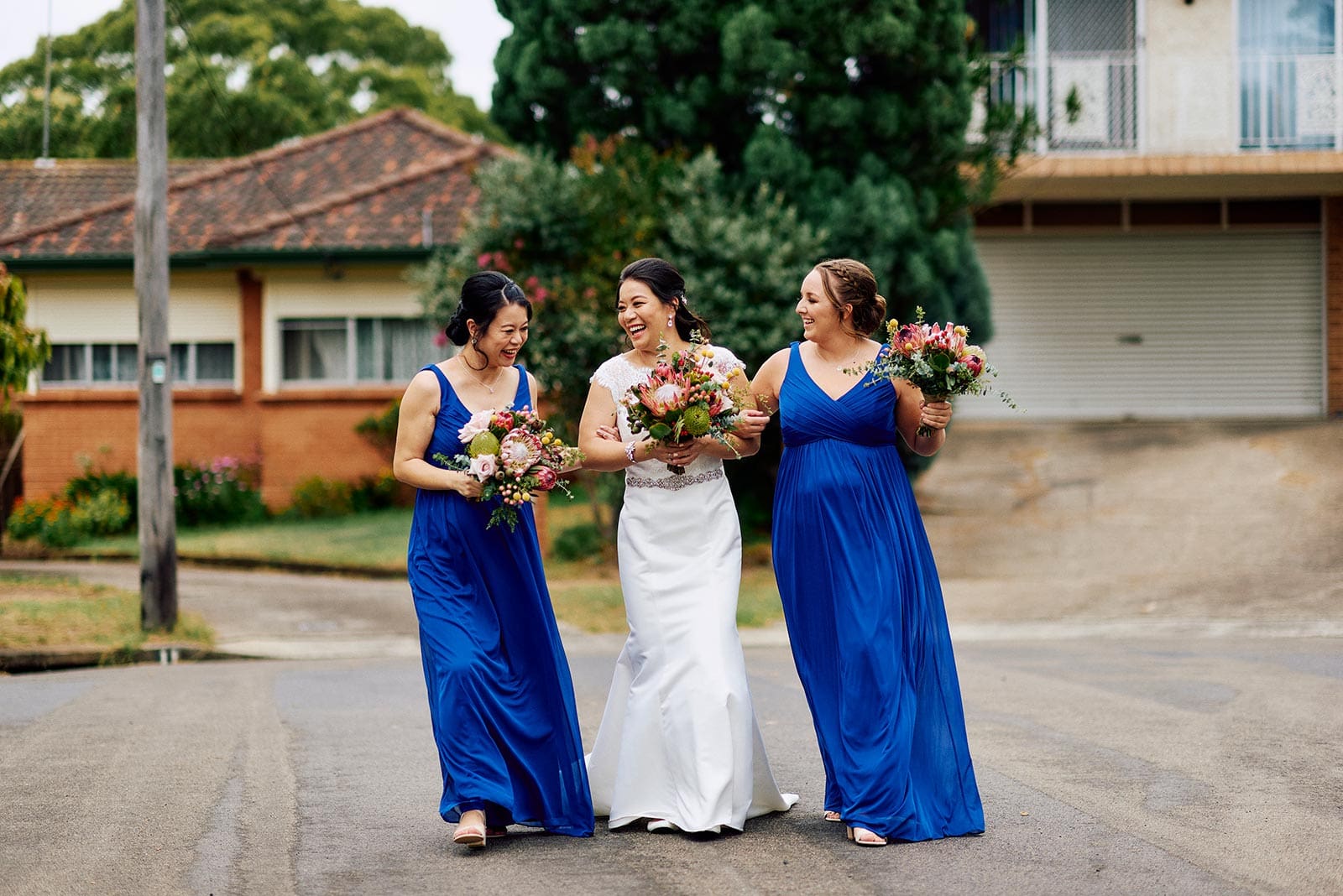Bride with bridesmaids out on the street of her family home